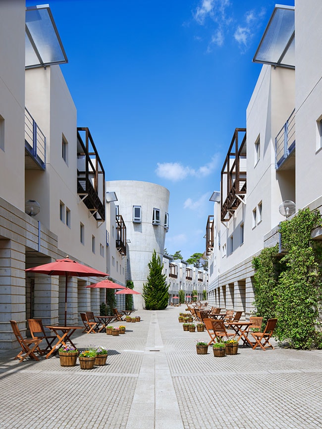 左：イタリアの有名建築家が設計した、非日常感あふれるリゾート内。
右：真冬でもビーチ気分を楽しめる、波の出るプール「イル マーレ」。