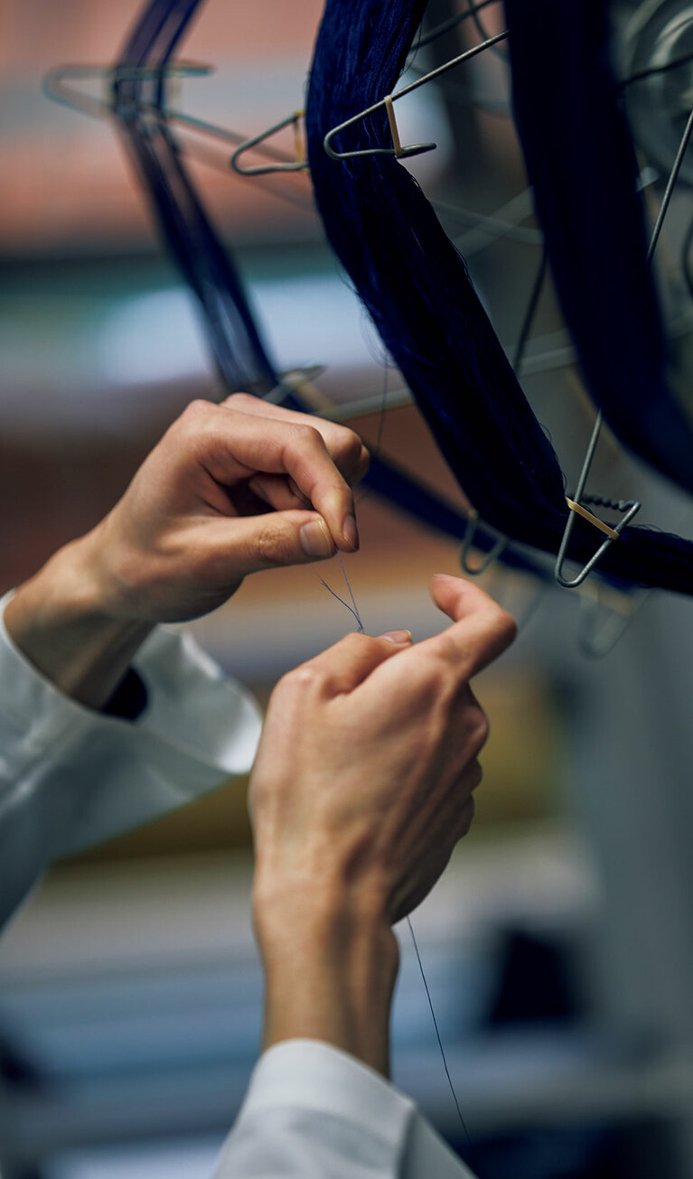 織る前の準備にも多くの工程がある。糸繰りでの均一になるよう常に手を添える作業は慎重さが求められる。