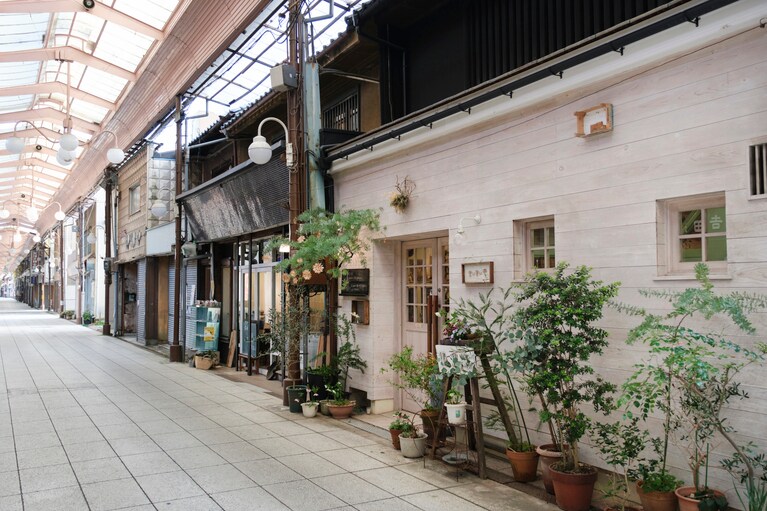 「まぃまぃ堂」は古い商店を改装した奥行きのあるお店。商店街の中で一際目を引くグリーンいっぱいの外観。