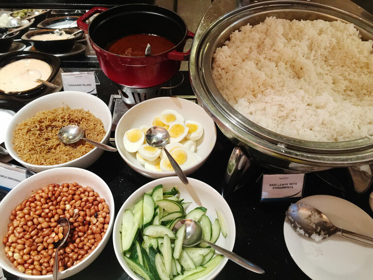 ナシレマッ。ココナッツミルクで炊いたご飯に、甘辛いソースのサンバル、塩気のきいた小魚、ゆで卵、きゅうり、ピーナッツをトッピングして好きに混ぜて食べる。それぞれ別皿に盛られているので分量はお好みで。サンバルは少しずつ混ぜて辛すぎないように。