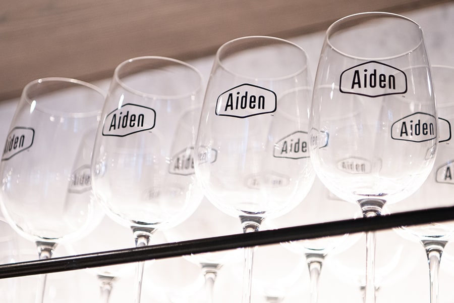 バーに並ぶ「Aiden」のロゴ入りグラス。