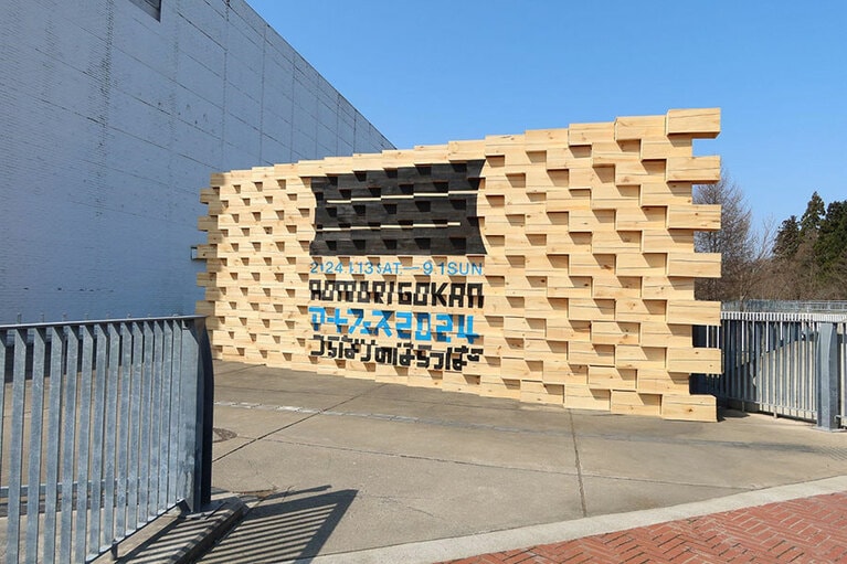 りんご箱を活用したオブジェが出迎える。青木淳《つらなりのはらっぱ のための壁》2024年