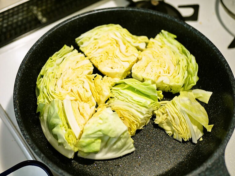 フライパンに油をひいて、春キャベツをひとかたまりずつのせていきます。写真のように、断面とフライパンが接するように置いてください。