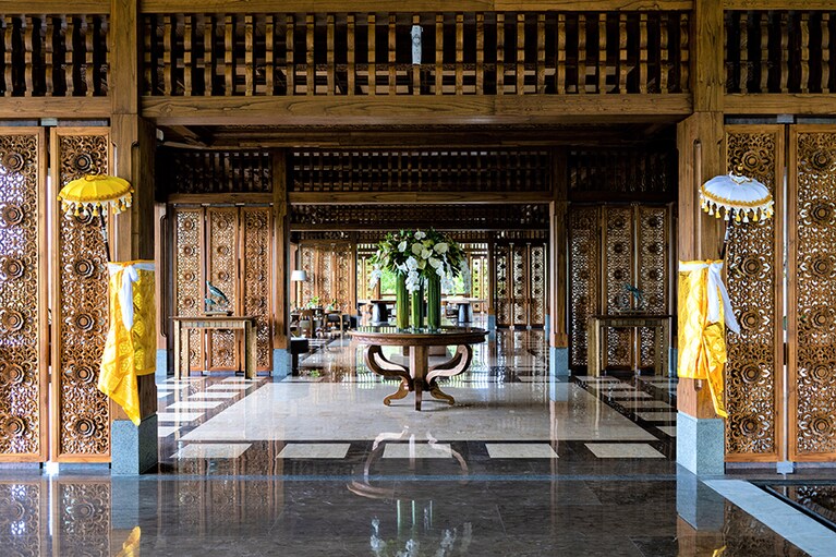 バリ伝統の木彫が風格を醸す「アヤナ セガラ バリ」のエントランス。天井を彩るバリ・ヒンドゥの神話の世界を描いたカマサン画も必見。