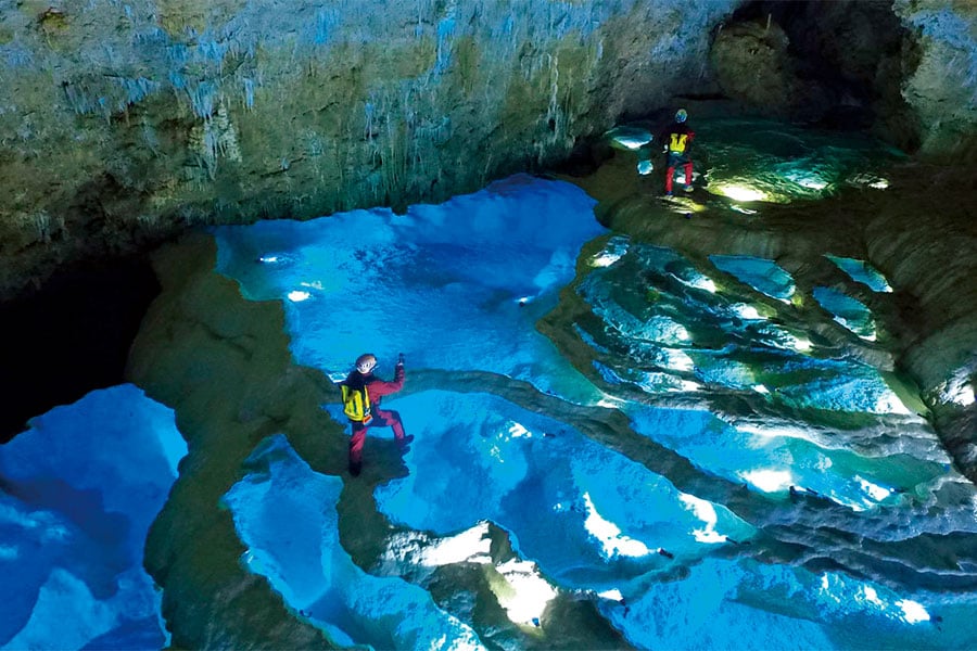 左：【沖永良部島】神秘の光景に圧倒される洞窟探検も体験可能な「銀水洞」。
右：【喜界島】心なごむキビ畑ののどかな風景。