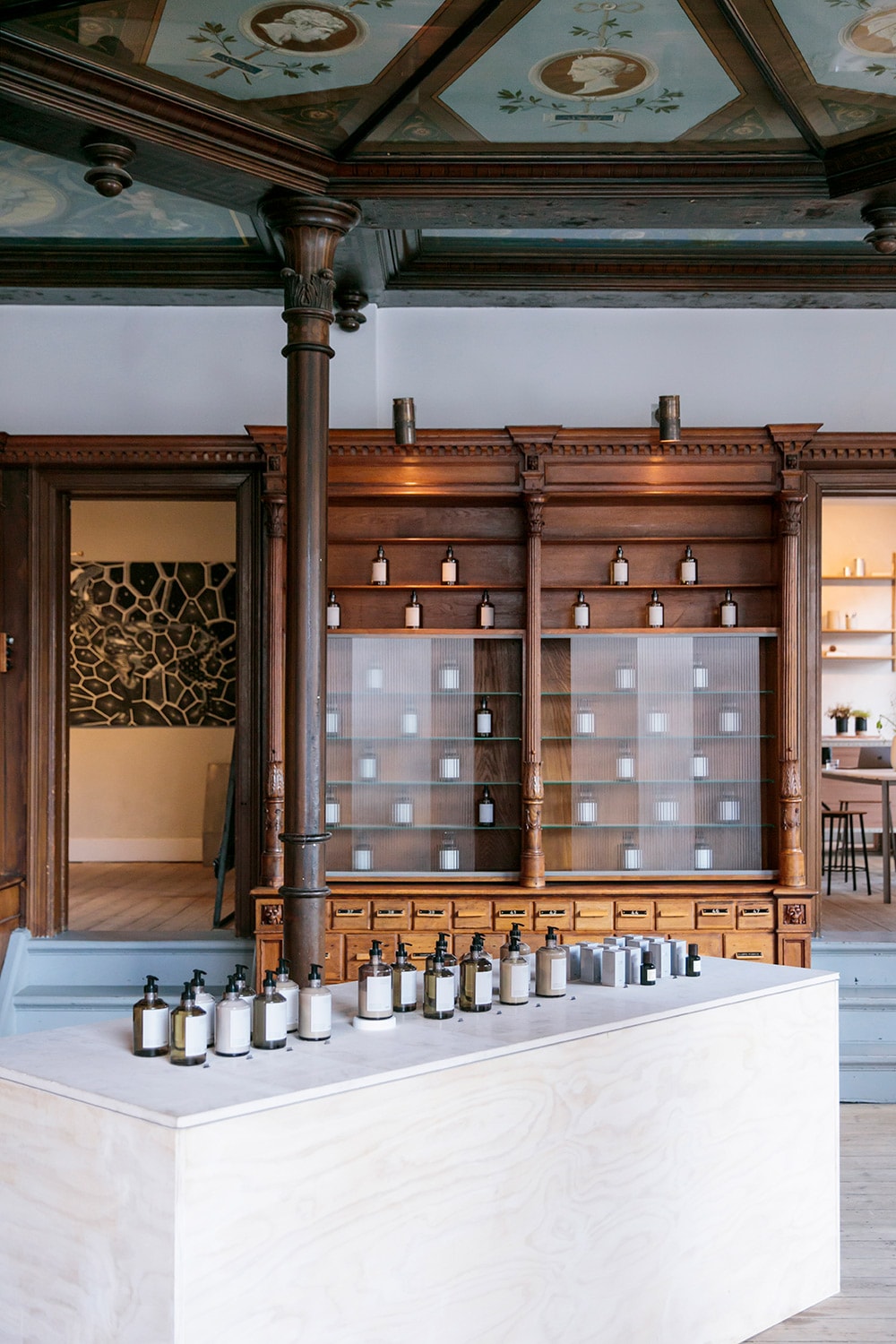 クラシックな薬棚の前には、アポセカリーシリーズが並ぶテーブル。美しい天井画にも注目。