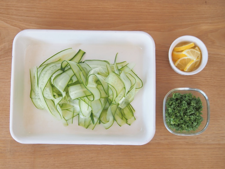 きゅうりはピーラーを使って帯状に削ぐ。飾り用のレモンは銀杏切りに、パセリはみじん切りにする。