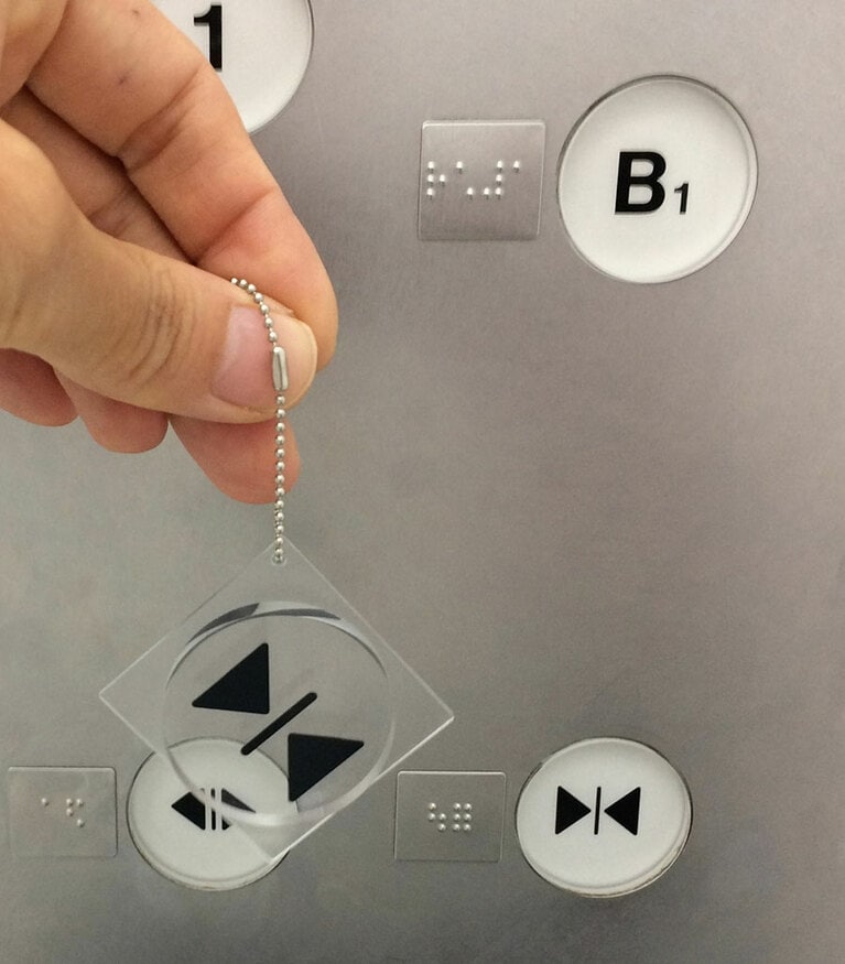 エレベーターでお馴染みの開閉ボタン。大きさはもちろん、原寸大の4×4cm。