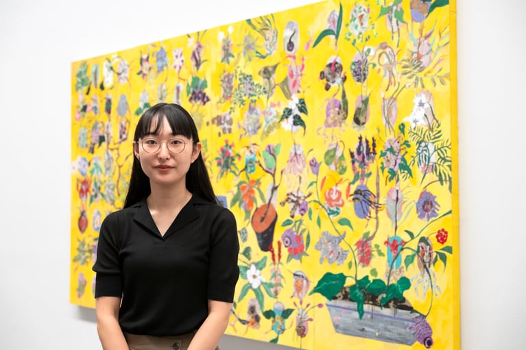 浅野友理子さん。大作《綯い交ぜの庭》2021 の前で。