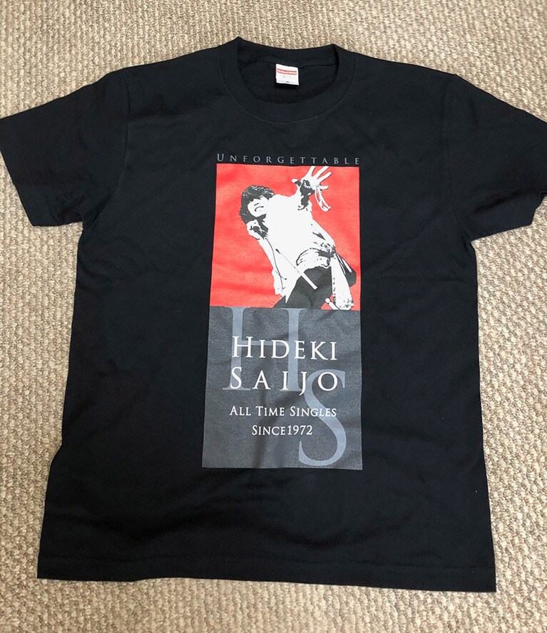 購入したTシャツ(M寸)。情熱的に手を伸ばすヒデキのプリントは卑怯！ こんなの買ってしまうに決まっているだろうが。背景を彩る地味なカーペットについては触れないでいただきたい。