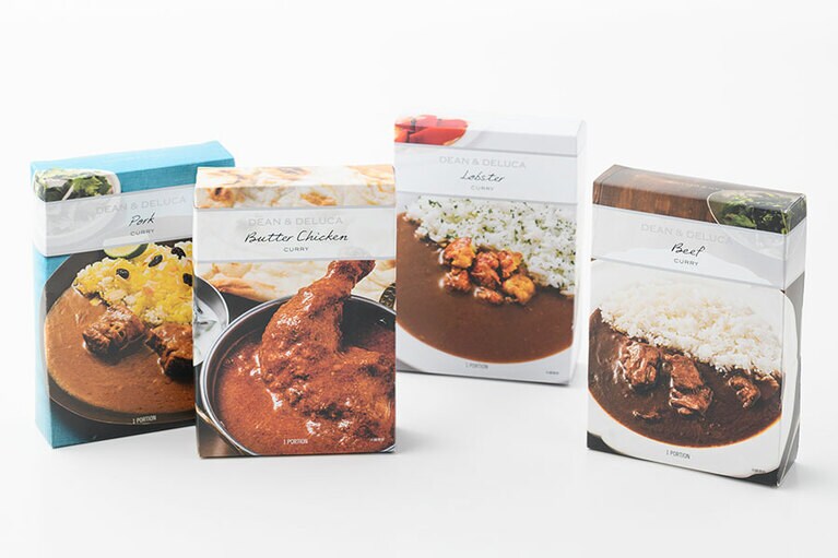 DEAN & DELUCA オリジナルカレー(各種1食分入り)。左から：クラッシクポークカレー 1,000円、骨付きモモ肉のバターチキンカレー 1,200円、オマール海老のカレー 1,500円。牛ほほ肉のビーフカレー 1,200円。※写真のポークカレーとビーフカレーのパッケージに記載されている商品名は、実際の商品名と異なります。発売は2020年8月14日(金)〜。