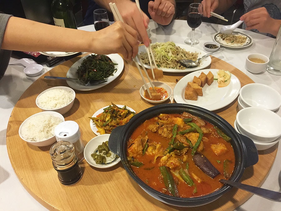 クアラルンプールで食べていたフィッシュヘッドカレー(右手前)。大ぶりの魚の頭を使い、土鍋で提供される。ひとつの鍋をみんなで取り分けていたので、日本の鍋を食べている感覚にも似ていた。