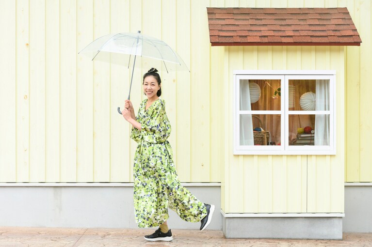 「PEDALA RIDEWALK 1212A208」のブラックには、カラフルで華やかなワンピースドレスをセレクト。可愛らしさの中にはつらつとした大人の女性の魅力があふれる、安藤さんらしいコーディネート。©Moomin Characters™