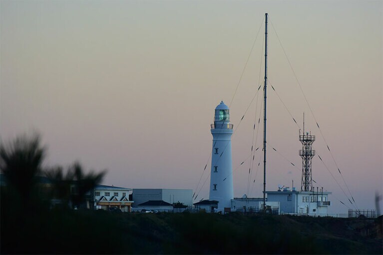薄暮に明かりが灯り始めた灯台。