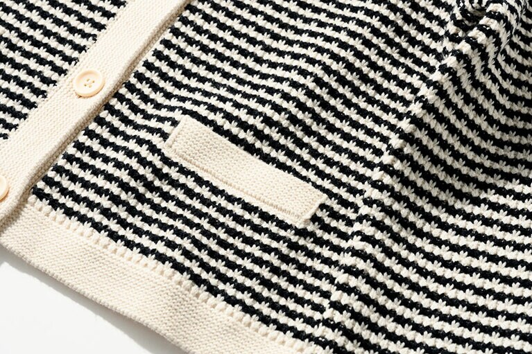 凹凸のある編み地と大きめなボタンがポイント。