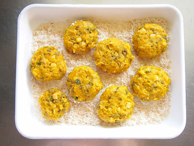 （5）バットにパン粉を広げ、丸く成型した（4）の生地を置きます。形が崩れないように気をつけながら裏返し、両面にパン粉をつけます。