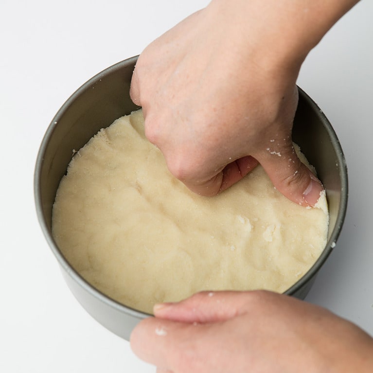 型に入れ、押さえながら型の底に敷き込み、フォークで穴をあける。