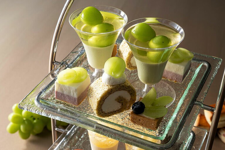 アフタヌーンティーの上段を彩るのは、「緑茶パンナコッタとシャインマスカットのジュレ」や「シャインマスカットと紅茶のロールケーキ」など。