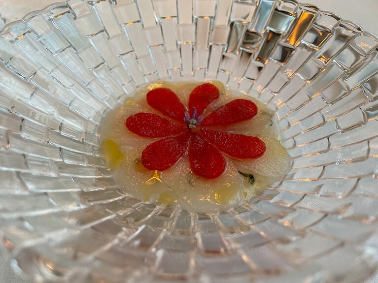 ヒラマサの刺身の上に発酵させたバラと洋梨で花のような模様。