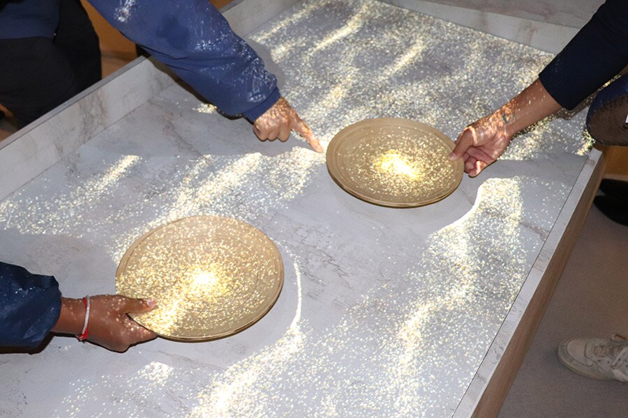 「黄金館」内で体験できる砂金採りシミュレーションゲーム。水に漂う砂金をお皿の上に集めると、数字が出現して運勢を占える。奥の人は「7」が出た。