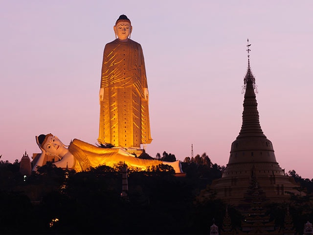 すっくと立つ仏像と寝転ぶ仏像が並ぶ ミャンマーの田舎の ...