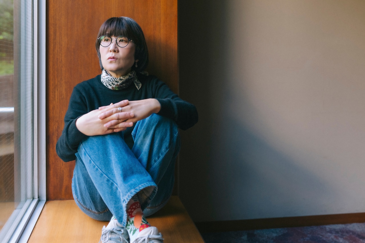 窓辺に座る光浦さん。