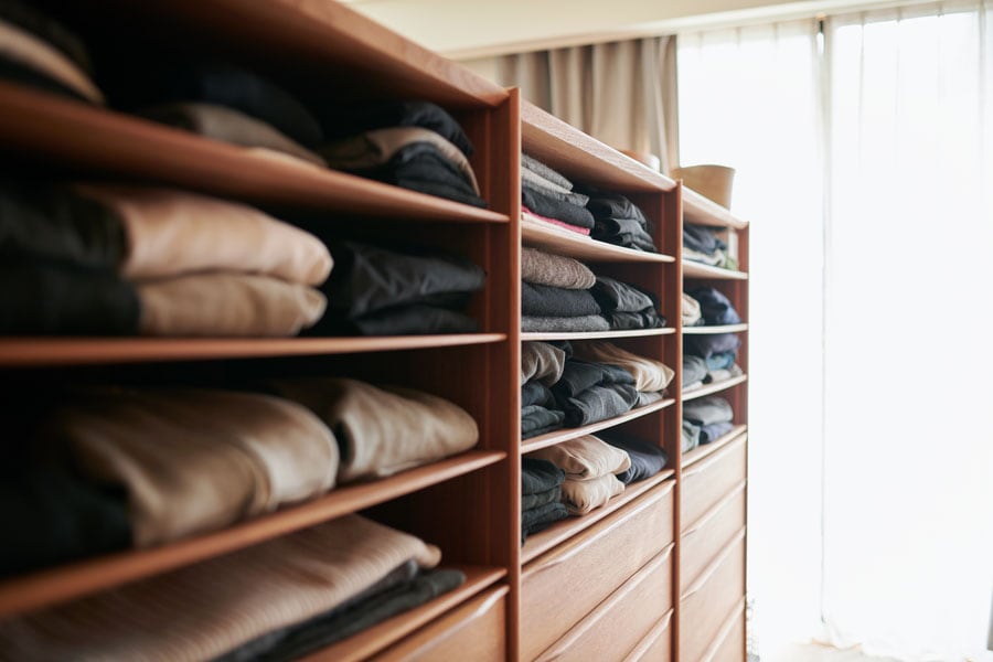 ヘッドボード裏を服の収納に。空間を効率よく使うことで、寝室は広々。