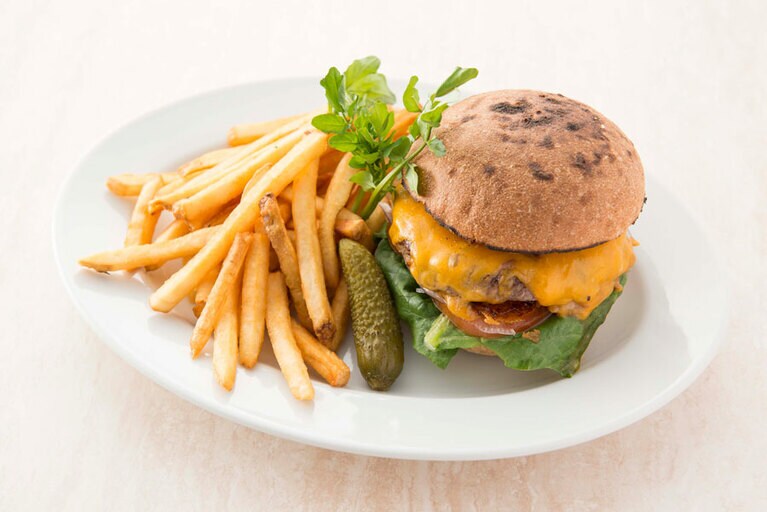 チェダーチーズが乗った分厚いパテに厚めのバンズ。迫力満点の「サラベスグレートバーガー」1,400円 (テイクアウトの際は専用容器での提供)。