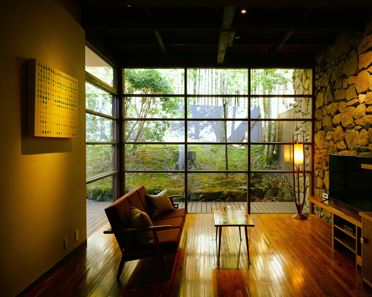 周囲に広がる森に溶け込んだかのような時間を過ごせる客室「暁」。古民家の内部に広がるモダンな空間が心からのくつろぎをもたらします。