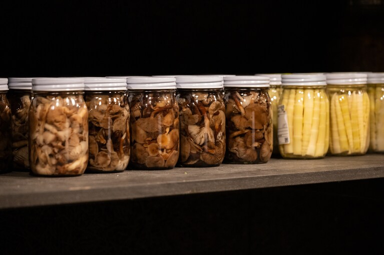 棚には、春に採った姫竹（ネマガリダケ）や秋に収穫したキノコなど瓶詰めされた保存食もずらり。