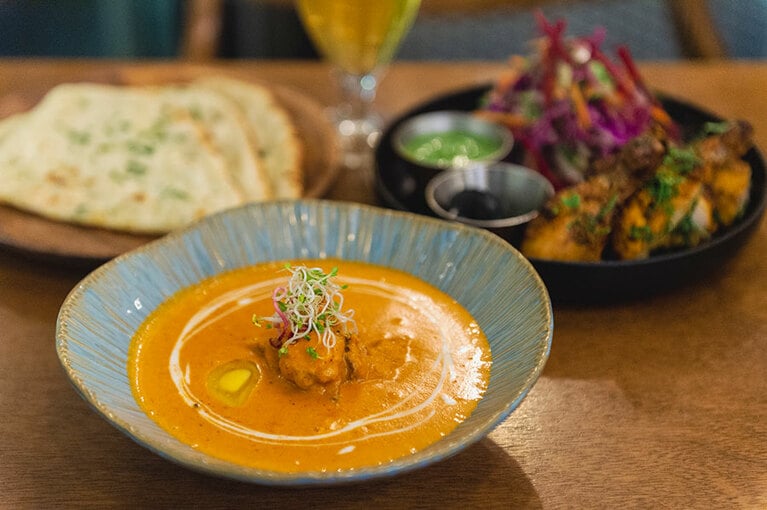 手前から時計回りに、インディカ バターチキン W22,000、ガーリックナン W4,000、タンドリーチキン W20,000。