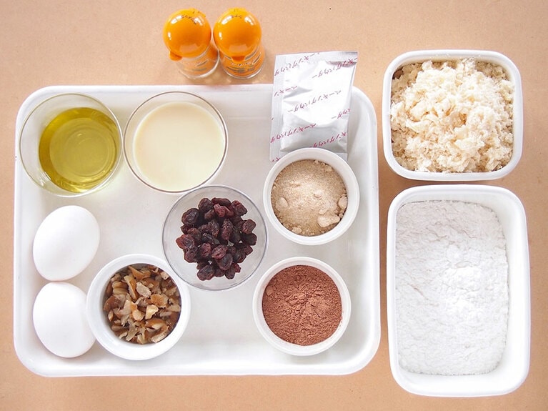 材料(18cmのパウンド型1台分)。［A］ ・卵：2個 ・砂糖：40g ・グレープシードオイル：30g  ・素焼きくるみ：大さじ1 ・レーズン：大さじ1  ［B］ ・生おから：100g ・豆乳：140g ・米粉：100g ・ココアパウダー：20g ・ベーキングパウダー：5g ・シナモン：小さじ1/2 ・ナツメグ：小さじ1/4