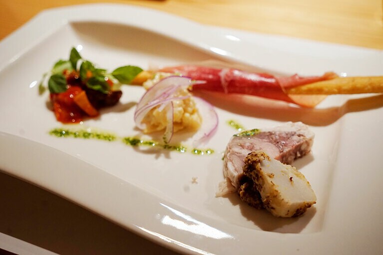 前菜は、手前から山田の里芋と自家製テリーヌ、マスタードポテトサラダ、トマト煮、鈴木シェフの奥さまが焼いた自家製プリッシーヌ生ハム巻き。ワインが進む！