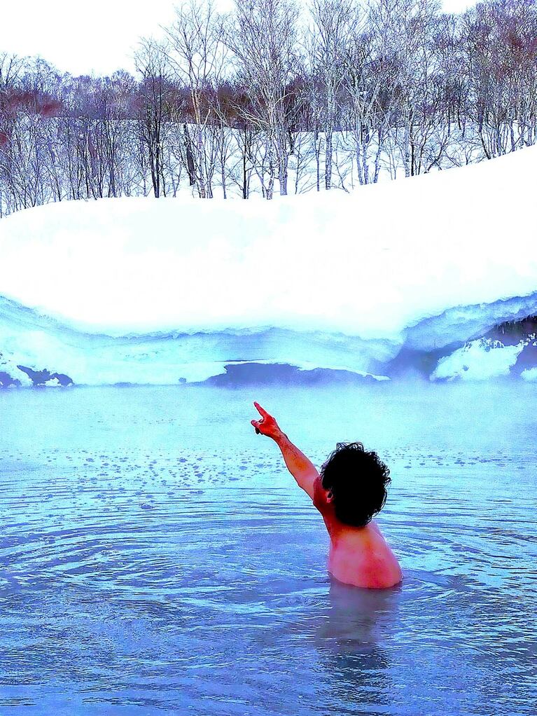 水中の岩礁の上に立って景色を堪能しながら湯浴みを満喫