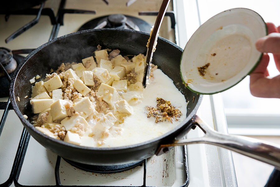 白マーボーは、マスタードホワイトソースを作るイメージで。豆腐を炒めた後に片側に寄せて、フライパンにスペースをつくって、そこで牛乳を注ぎ、味噌と粒マスタードを溶いていきます。そうすることで調味料がきちんと混ざった状態にできるし、その上で豆腐などに絡めていくことで豆腐が型崩れしていくのも防げます。