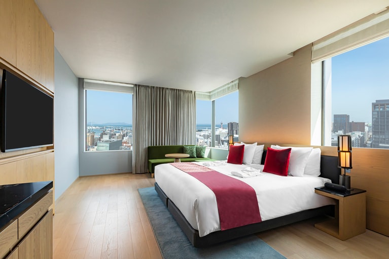 2面に広がる窓から活気ある天神の街並みが広がる、客室の一例「Luxe」。