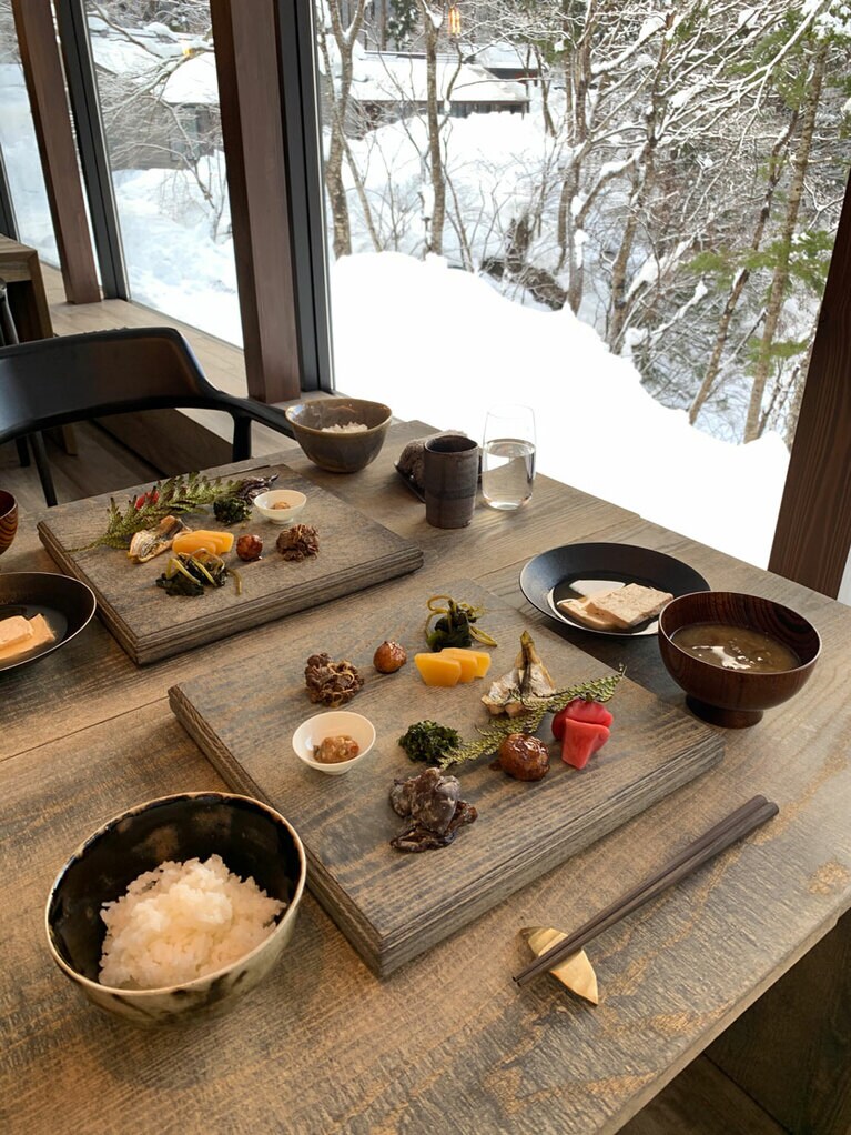 朝食は、赤かぶ漬けをはじめ、かっちり(じゃがいも)、きくらげ、ハタハタの開き、かぶの葉の和え物、南蛮味噌、染めカボチャ、センナ、鹿のしぐれ煮など。器だけでなく、器と同じ素材のテーブルもすべてオリジナルだ。
