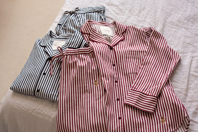 肌にすっとなじむ、ネル素材のストライプパジャマ。パイピングがきいている上品なルックスは、自分へはもちろん、親への贈りものとしても最適。裾にあしらわれたベアに注目を。レディースはレッドでメンズはネイビー。パイピングストライプシャツ、パイピングストライプロングパンツレディース 各7,260円、メンズ各7,590円。