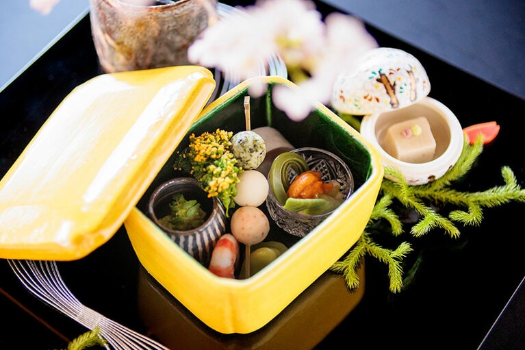 花見弁当を思わせる蓋物。愛らしい三色団子は百合根をベースに作られている。