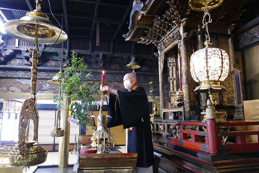 50匁の和蝋燭を仏壇に供える住職。