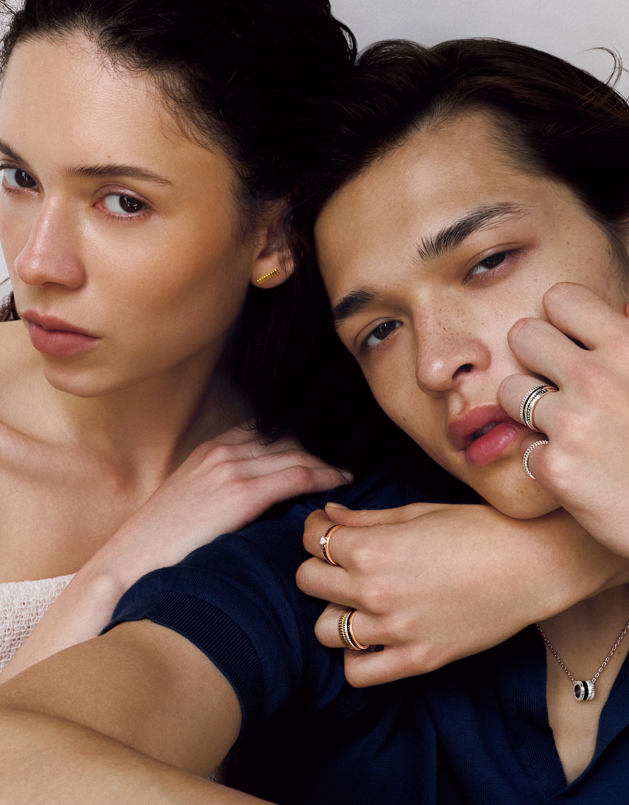［女性］ リング：〈人差し指〉「キャトル クラシック」ソリテール リング（YG×PG×ブラウンPVD×ダイヤモンド）434,500円～、〈薬指・上から〉「キャトル ラディアント」グログラン・ゴドロンリング（YG）271,700円、「キャトル クラシック」ダイヤモンド リング エクストラスモール（YG×PG×WG×ブラウンPVD×ダイヤモンド）720,500円　イヤリング「キャトル グログラン」スタッズイヤリング（YG）295,900円（すべて予定価格）／すべてブシュロン（ブシュロン クライアントサービス）　ドレス 77,000円／イン（ショールーム セッション）　［男性］ リング：〈薬指・上から〉「キャトル ブラック」ダイヤモンド リング エクストラスモール（WG×ブラックPVD×ダイヤモンド）775,500円、「キャトル ラディアント」リング ハーフ（PT）245,300円、〈小指〉「キャトル ラディアント」グログラン・ゴドロンリング（PT）330,000円　ペンダント「キャトル ブラック」ペンダント ラージ（WG×ブラックPVD×ダイヤモンド）973,500円（すべて予定価格）／すべてブシュロン（ブシュロン クライアントサービス）　ポロニット 47,300円／ジョン スメドレー（リーミルズ＆カンパニー）