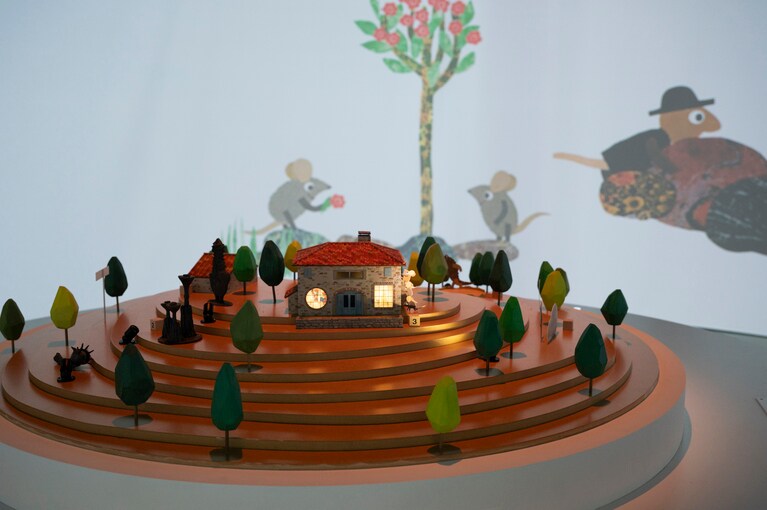 ボタンは数種類、ジオラマを囲むようにあり。「レオ・レオーニの絵本づくり展」展示風景、ヒカリエホール、2025年