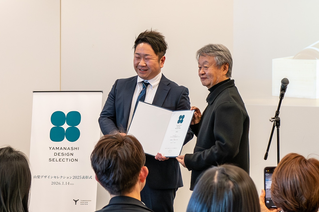 「“エクスプレッション シリーズ”1750年から紡ぐ七賢の持続可能なデザインの力」の事業者・山梨銘醸の代表代理人に表彰状を授与する深澤選考委員。