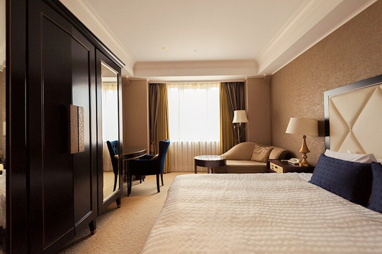 「本館の客室グランドダブル」は、コンパクトながら高い天井と重厚な調度品はさすが。