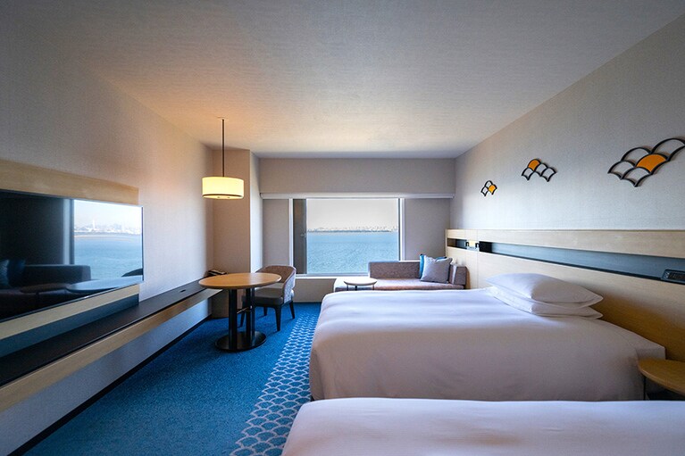 窓の外にベイエリアの爽快な風景が広がるヒルトン東京ベイの客室「エグゼクティブセレクト」。美しく整えられたリネンなど、細部にまでヒルトンのホスピタリティが行き届きます。