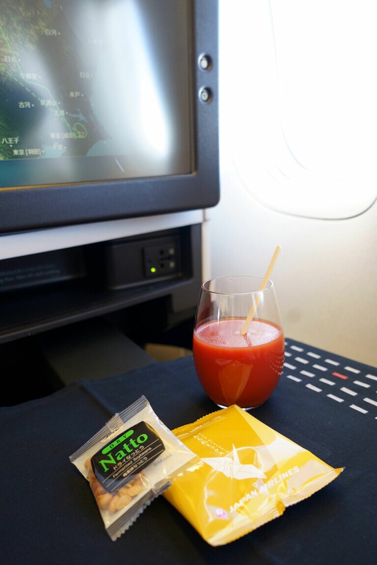 まずはトマトジュースから。おつまみはあられとDry Natto(乾燥納豆)の2種類。やっぱりガラスのグラスは旅気分が盛り上がる！