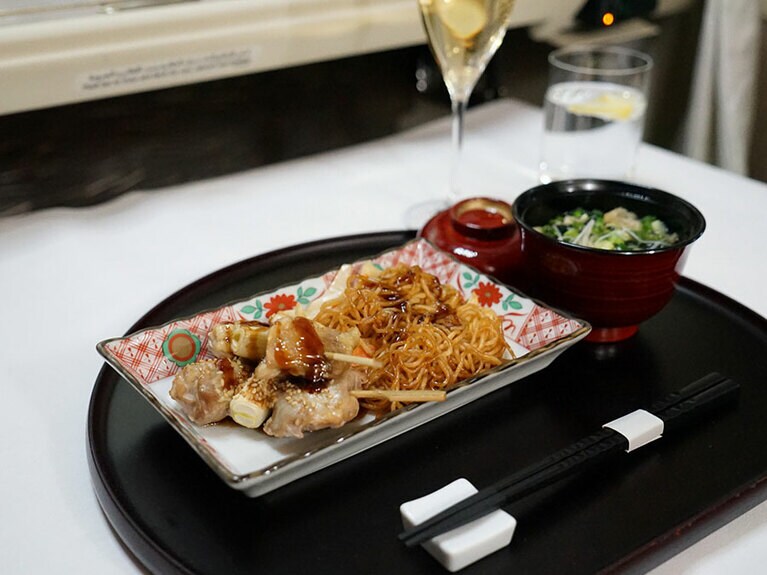 焼き鳥には照り焼きソースを使った焼きそばとお吸い物が添えられている。