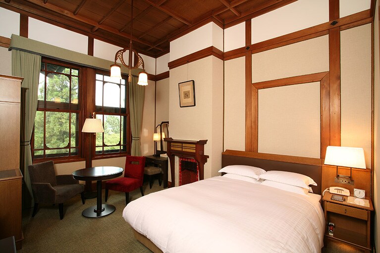 本館「スタンダードダブル」はマントルピースのオブジェも。大正時代から使われている調度品が飴色に輝く。