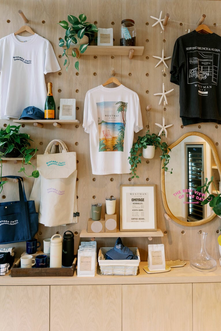 店内で販売しているオリジナルグッズ。コーヒー豆（22ドル）、Tシャツ（35ドル）、マグカップ（15ドル）、タンブラー（48ドル）など。