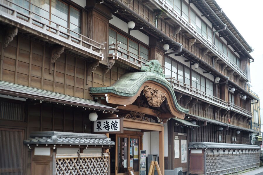 風格のある唐破風の玄関には、地元の彫師・森田東光が緻密に彫りあげた旭日や鶴の飾り。